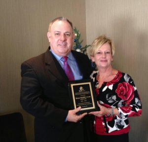 Former CACM chair Bruce Ratliff receives memorial plaque from current Chair Melinda Young